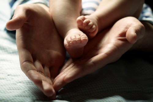 Detail picture of the baby's feet in mother's hands