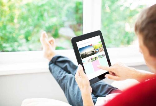 Man using tablet on sofa at home