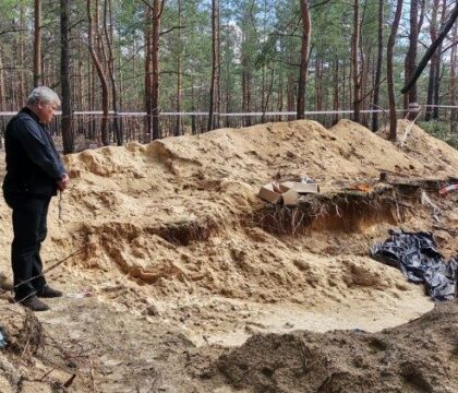 Le cardinal Krajewski en prière devant les fosses communes d&rsquo;Izioum