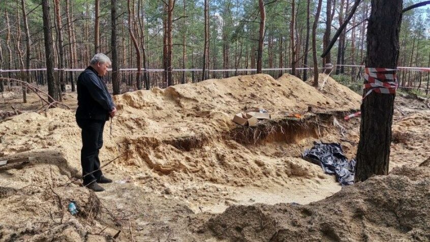 Le cardinal Krajewski en prière devant les fosses communes d&rsquo;Izioum