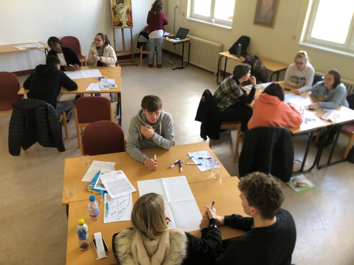 Photo des jeunes travaillant en groupe lors de la retraite sociale.